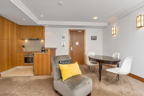 a living room with a table and a chair at QV Stays Peace and Style in the Iconic Metropolis in Auckland