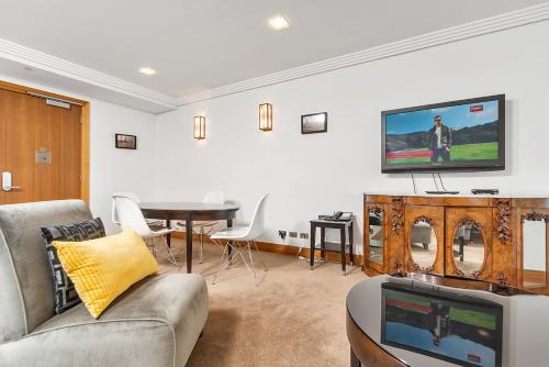a living room with a couch and a tv at QV Stays Peace and Style in the Iconic Metropolis in Auckland