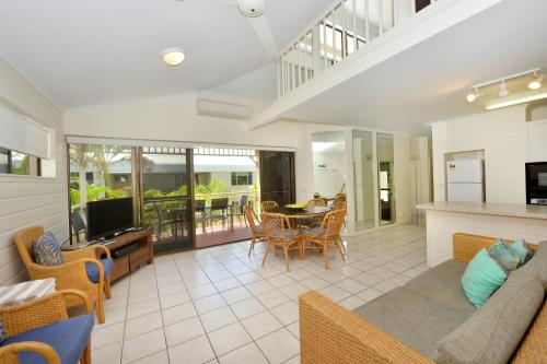 a living room with a couch and a table at Driftwood Mantaray - Official Onsite Reception and Check In in Port Douglas