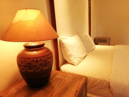 a lamp sitting on a table next to a bed at Coco Country Homes in Melaka