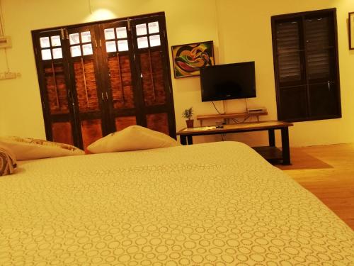 a bedroom with a bed and a tv and a window at Coco Country Homes in Melaka