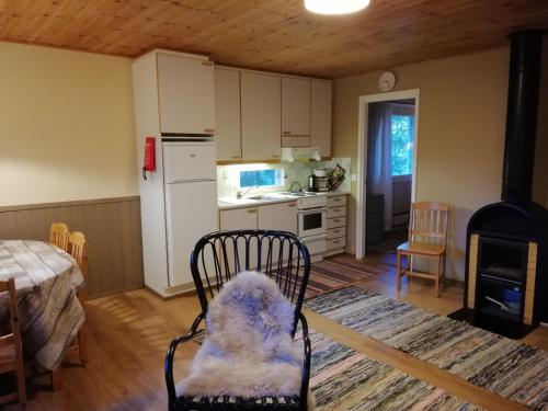 una cocina con una silla y una cocina con estufa en Tikkamäki, en Orivesi
