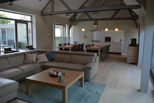 una sala de estar con un sofá y una mesa en Vakantiewoning Den Landman, en Nieuwpoort