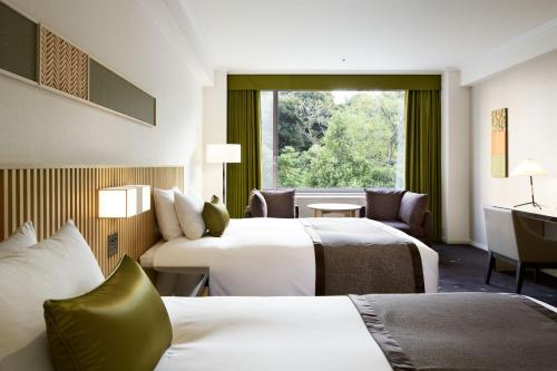 a hotel room with two beds and a window at The Prince Sakura Tower Tokyo, Autograph Collection in Tokyo