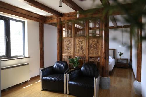 two black leather chairs in a room with a bed at Beijing Downtown Travelotel in Beijing