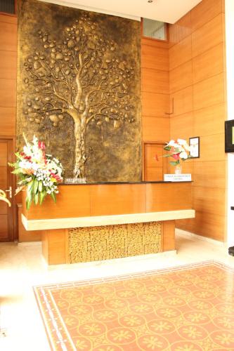 a room with a bench with flowers on the wall at Coraltree Hotel Bangalore in Bengaluru