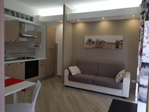 a living room with a couch and a kitchen at Residenza Lumière in Termoli