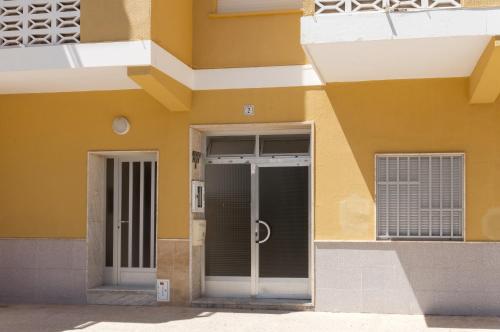 a facade of a yellow building with a door at River in Daimuz
