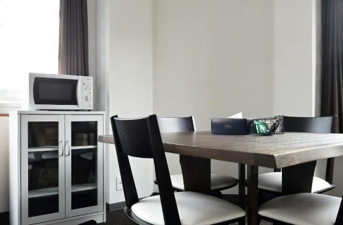 a dining room table with chairs and a microwave at The Wonder At Stay-Tengachaya- in Osaka