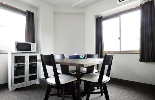 a table and chairs in a room with windows at The Wonder At Stay-Tengachaya- in Osaka