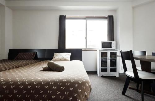 a bedroom with a bed and a desk and a window at The Wonder At Stay-Tengachaya- in Osaka