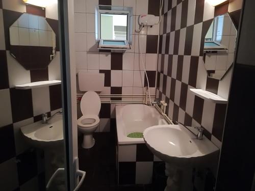 łazienka z umywalką, toaletą i wanną w obiekcie Vila Popoiu w mieście Costinesti