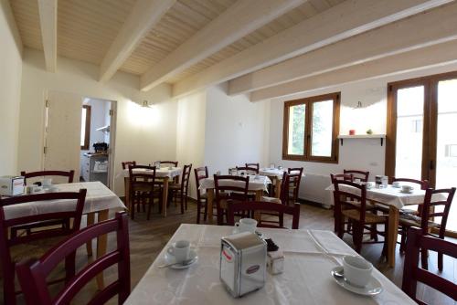 a dining room with tables and chairs and windows at La Cerqua in Arcevia