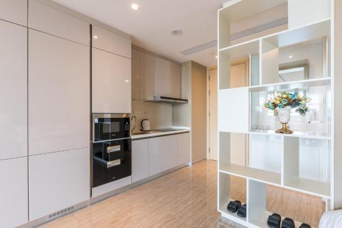 a kitchen with white cabinets and a vase of flowers at Van-Pretty Residence Haitang Bay Sanya in Sanya