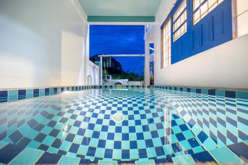 a swimming pool with a blue and white tile floor at เลทซี&กรีนเวฟ หัวหิน พูลวิลล่า เดินลงทะเล100เมตร Let's Sea & Greenwave Hua-Hin Pool Villa walk to beach 100M in Hua Hin
