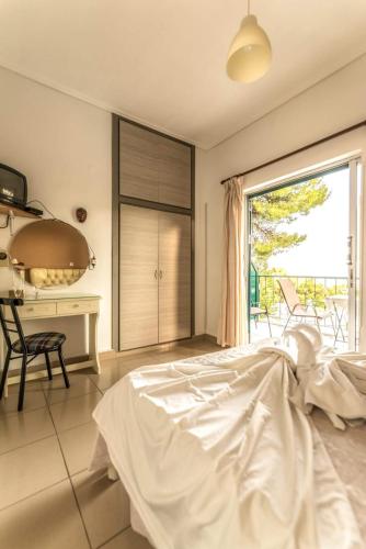 a bedroom with a bed and a desk and a window at Mina Apartments in Poros