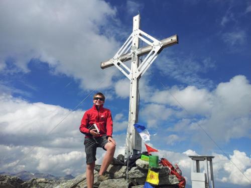 a man sitting in front of a white cross at alpenrose hotel-garni in Gerlos