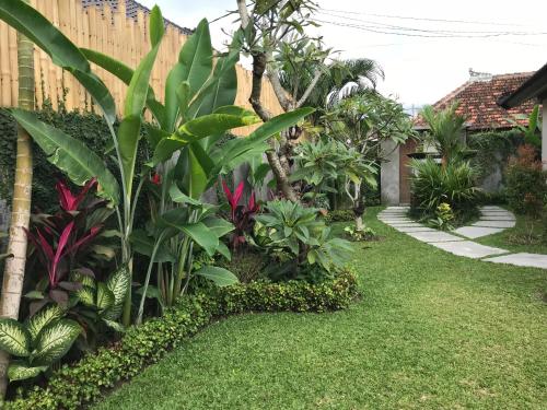 a garden with green plants and a fence at Rumah Dadong in Ubud