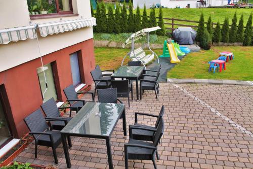 a patio with tables and chairs and a playground at Hotel Crisalpin in Poiana Brasov