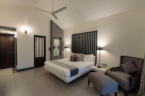 a bedroom with a bed and a couch and a chair at Andores Resort And Spa - Calangute in Calangute