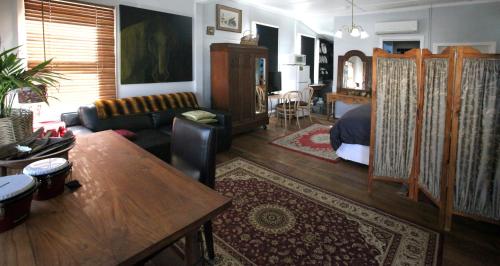a living room with a bed and a couch at Wallace Lodge - PID-STRA-16871 in Braidwood