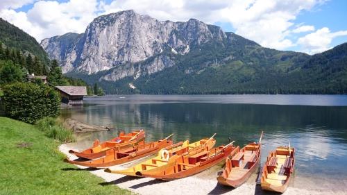 a group of boats sitting on the shore of a lake at Hotel am See - Seeresidenz in Altaussee