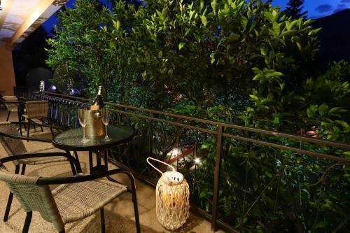 a table and chairs on a balcony with a hedge at Apartments Amigo in Kotor