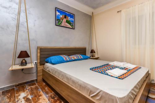a small bedroom with a bed with blue pillows at Apartments Amigo in Kotor