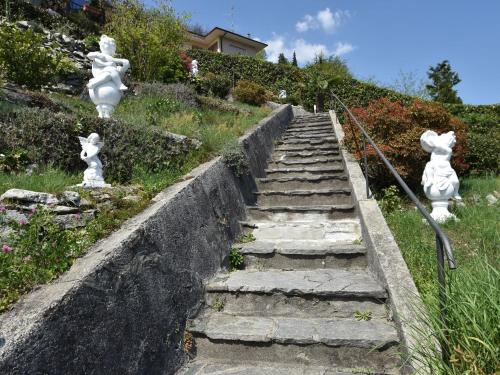 un conjunto de escaleras de piedra con estatuas de ratones en Belvilla by OYO Capriccio, en Ghiffa