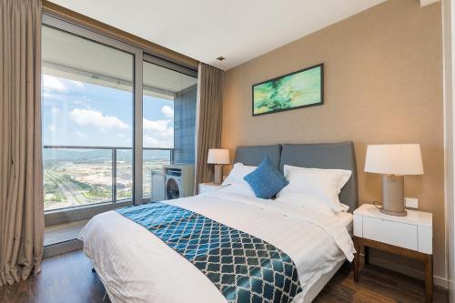 a bedroom with a bed and a large window at Van-Pretty Residence Haitang Bay Sanya in Sanya