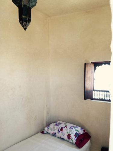 a small room with a pillow and a window at La Tour de L'air in Tangier