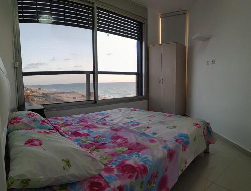 a bedroom with a bed and a large window at Hotel Apartment Short Term Tel Aviv Bat Yam 5 in Bat Yam