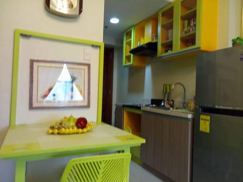 a kitchen with a table with a bowl of fruit on it at Nica's Place Property Management Services at Horizons 101 Condominium in Cebu City