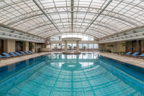 a large swimming pool with a glass ceiling at Radisson Blu Hotel Shanghai New World in Shanghai