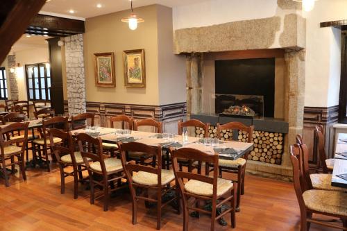 a dining room with tables and chairs and a fireplace at Le Mouton Blanc in Le Mont Saint Michel