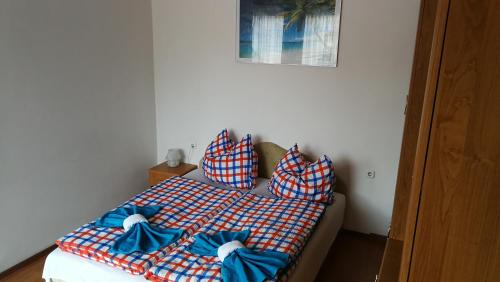 a bedroom with a bed with blue pillows on it at Dunakanyar Bed & Breakfast Panzio in Göd