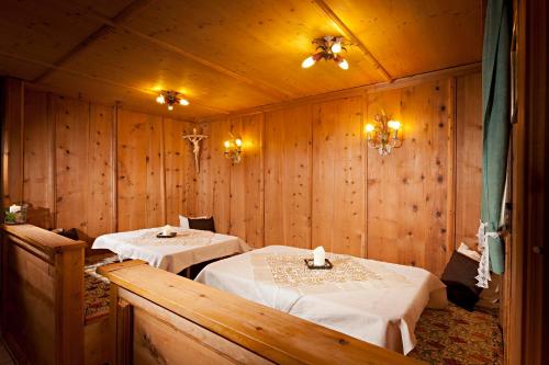 a dining room with two tables in a room with wooden walls at Ferienhaus Knor in Umhausen