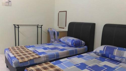 two beds sitting next to each other in a room at J&P Homestays House 1 in Kampar