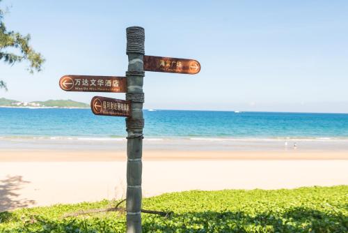 a pole with street signs in front of a beach at Van-Pretty Residence Haitang Bay Sanya in Sanya