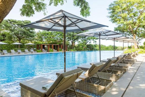 - une rangée de chaises et de parasols à côté de la piscine dans l'établissement Van-Pretty Residence Haitang Bay Sanya, à Sanya