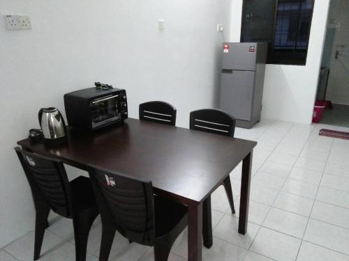 a kitchen with a table with chairs and a microwave at J&P Homestays House 1 in Kampar