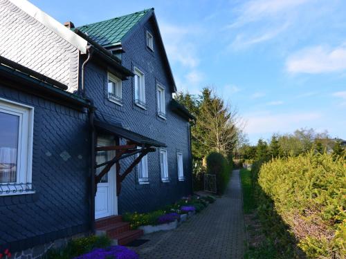 ノイシュタット・アム・レンシュタイクにあるHoliday Home in Neustadt am Rennsteig with Gardenの白い扉と私道のある青い家