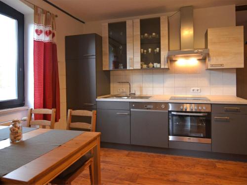 a kitchen with stainless steel appliances and a wooden table at Pleasant Apartment in Kierspe with Private Terrace in Kierspe
