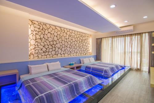 1 dormitorio con 2 camas y un cuadro en la pared en Little SkyLark B&B, en Magong