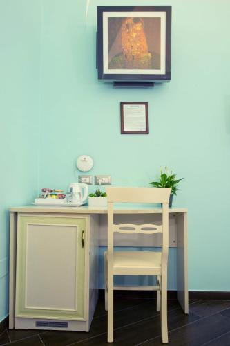 a desk with a chair and a picture on the wall at Relais Parallelo 41 in Vieste