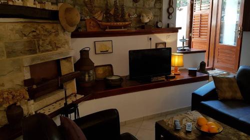 uma sala de estar com um sofá e uma televisão em Mama's & Papa's house em Vrboska