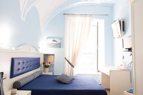 a bedroom with a blue bed and a window at Relais Parallelo 41 in Vieste