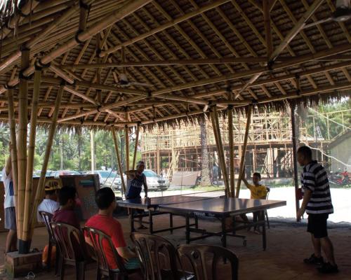 a group of people sitting around a ping pong table at Tadom Hill Resorts in Kampong Labohan Dagang