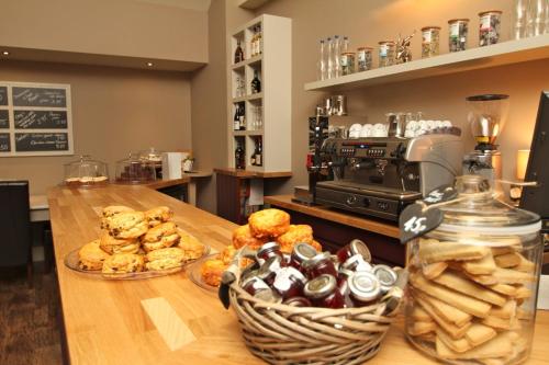 a table with two plates of pastries and a basket of bread at Breckland Lodge in Attleborough