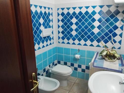 a blue and white bathroom with a toilet and a sink at Appartamenti Sardegna in Porto San Paolo